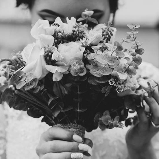 Bouquet de fleurs devant le visage de la mariée